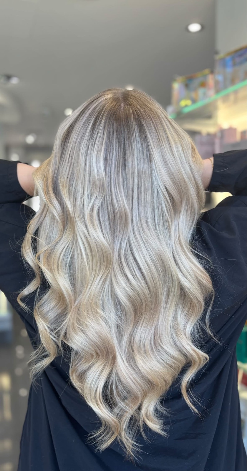 Bright, blended blonde with glossy waves after a full transformation
