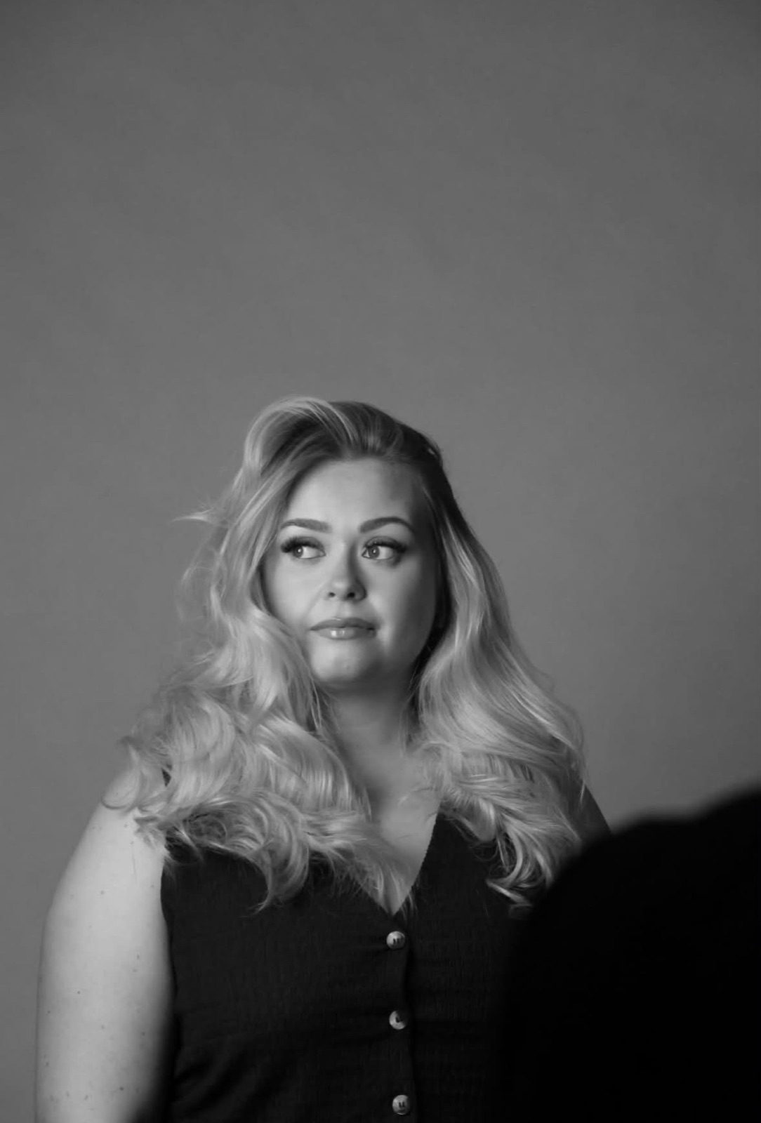 Black-and-white editorial portrait with voluminous blow-dried waves